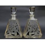 A pair of Art Deco glass decanters of triangular form with black flash overlaid and engraved