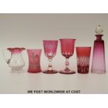 Six pieces of cranberry glassware comprising three flash overlaid cut glasses, Mary Gregory jug,