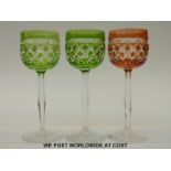 A set of three flash overlaid cut glass wine glasses with faceted stems on star cut bases,