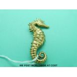 A yellow metal brooch marked 18k in the form of a sea horse with ruby eyes (25.