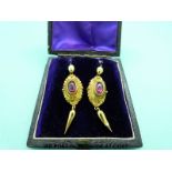 A pair of Victorian yellow metal earrings set with garnet cabochons