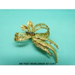 An 18ct gold brooch in the form of a stylised bow with textured finish,