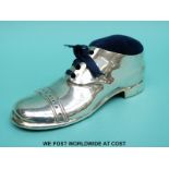 A large George V hallmarked silver pin cushion formed as a shoe with an oak sole,