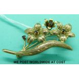 A 9ct gold brooch in the form of three flowers set with garnets (5.