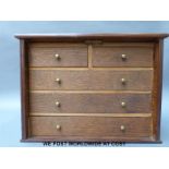 An oak collector's chest of drawers with lockable front flap