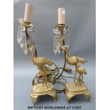 A pair of gilt metal style table lamps in the form of storks