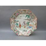 A Chinese octagonal charger decorated with three figures holding a scroll painting,