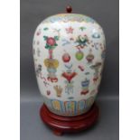 A Chinese ginger jar decorated in the 100 antiques pattern on turned wooden base, with matching lid,