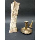 A carved African bone and a brass chamber stick