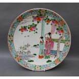 A Chinese charger decorated with two geishas under a peach tree,