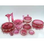 Nineteen cranberry glass bowls, vases, dishes etc all with applied decoration,