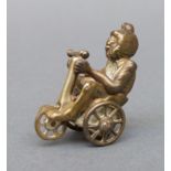 A novelty cigar cutter in the form of a monkey riding a bike,