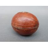 A novelty travelling inkwell in the form of a rugby ball,