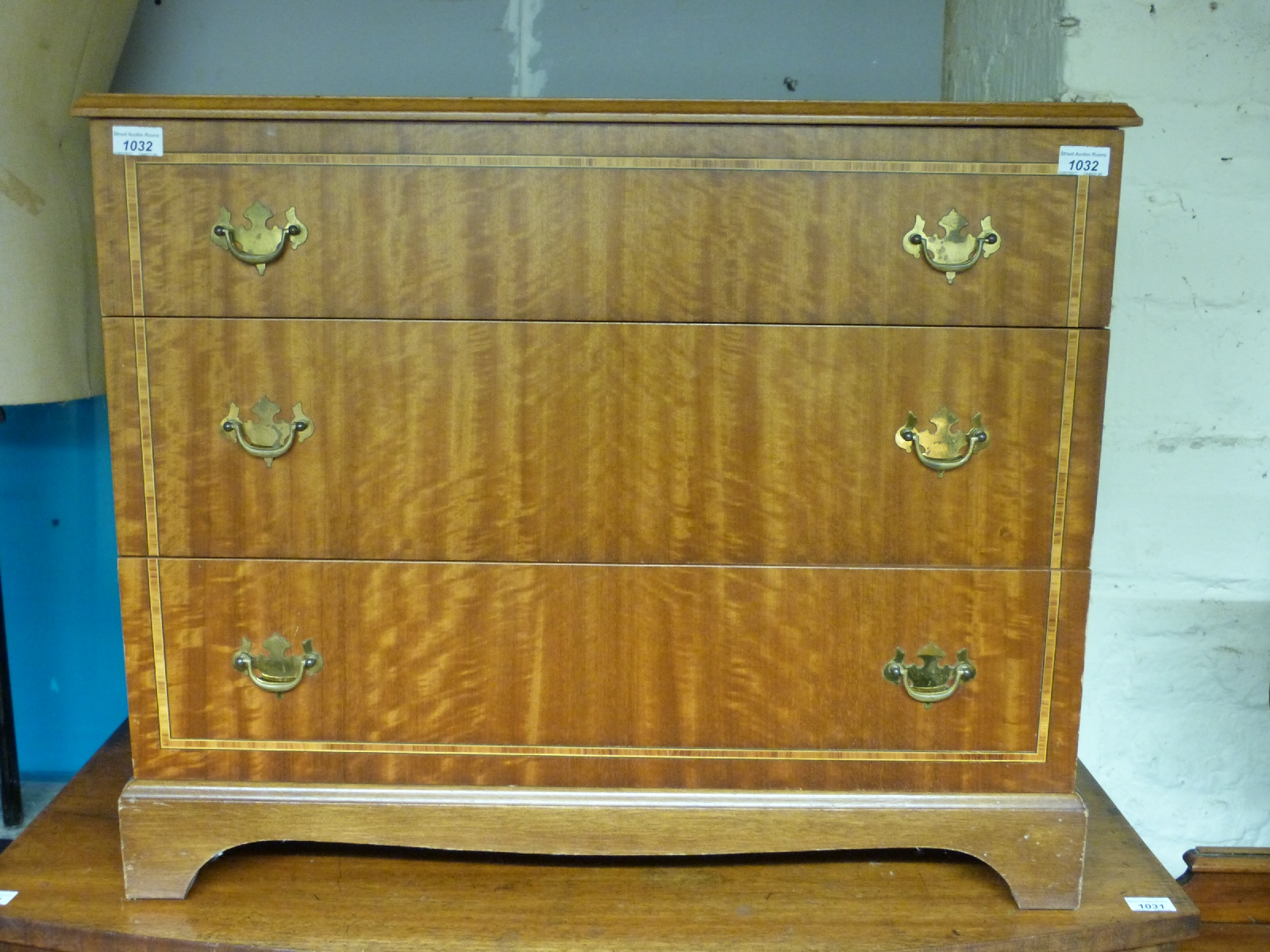 A crossbanded chest of three graduated drawers (H67 x W81 x D46cm)