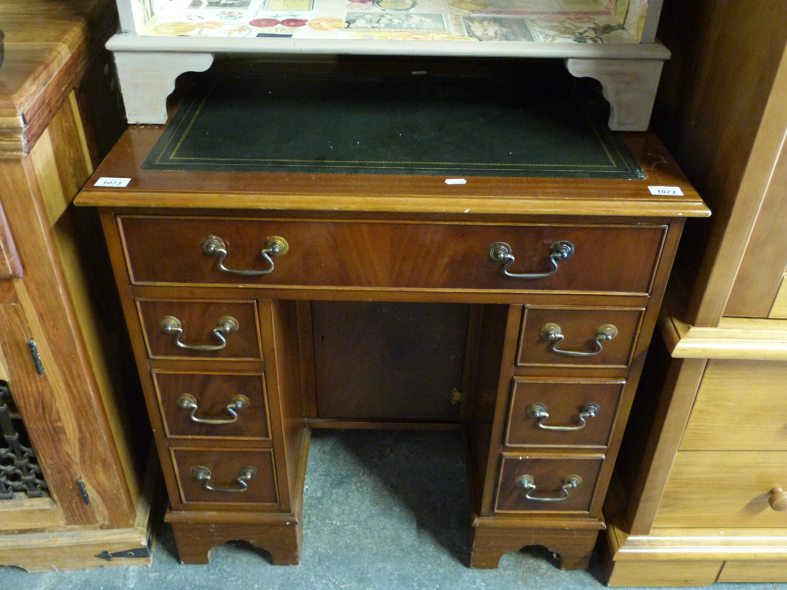 A pedestal desk with single drawer to the top and three drawers to either side and leather inset