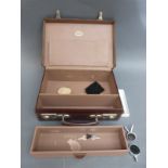 A small doctor's leather suitcase containing stethoscope diaphragm including one with teaching