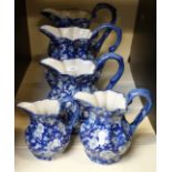 Five blue and white graduated jugs