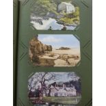 An Edwardian postcard album with colour and black and white postcards,