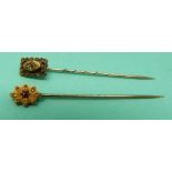 Two 15ct gold stick pins one set with a diamond,