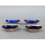 Four Victorian and later hallmarked silver basket shaped open salts with blue glass liners,