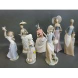 A collection of Nao figurines including girls with baskets, puppy, flowers,