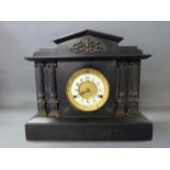 A late 19thC black slate mantel clock in classical architecture style with reeded Roman columns