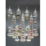 Ten Galileo-style glass thermometers with multicoloured liquids,