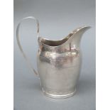 A Georgian hallmarked silver cream jug with engraved decoration marked with Georgian duty mark,