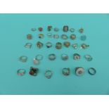 A collection of 33 silver/white metal dress rings including ruby, pearl,