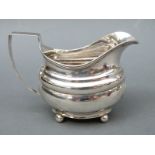 A Georgian hallmarked silver cream jug raised on four ball feet, London 1813, maker William Weston,