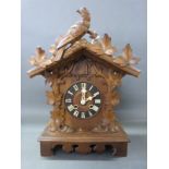 An early 20thC Black Forest two train mantel cuckoo clock striking on a gong with vine leaf and