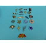 A collection of brooches to include glass, enamel flowers, leaves,