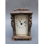 Brass carriage clock of small proportions, the columns decorated with semi-clad female forms,