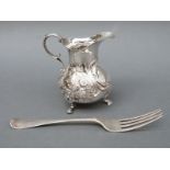 A Victorian hallmarked silver cream jug raised on three feet, London 1874, maker's mark EE FE,
