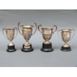 Four various mid 20thC twin handled trophy cups including an unengraved example,