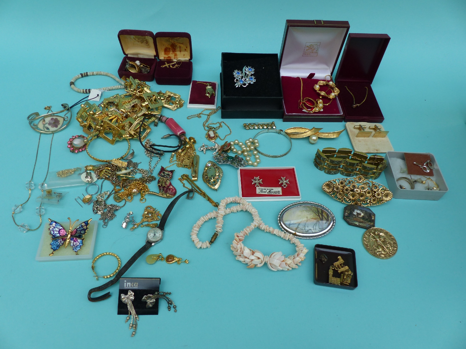 A collection of jewellery to include a shell necklace, silver necklaces, silver bracelet, brooches,