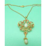 An Edwardian 15ct gold pendant set with seed pearls and two opal cabochons on a 15ct gold chain,