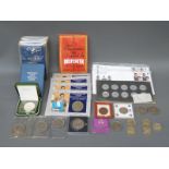 A collection of commemorative coins in packets 'Britains First Decimals', cased crowns,