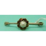 A 9ct gold brooch in the form of a flower with a freshwater pearl to the centre