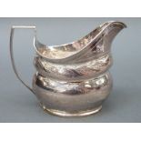 A Georgian hallmarked silver cream jug with chased decoration, marks rubbed but circa early 19thC,