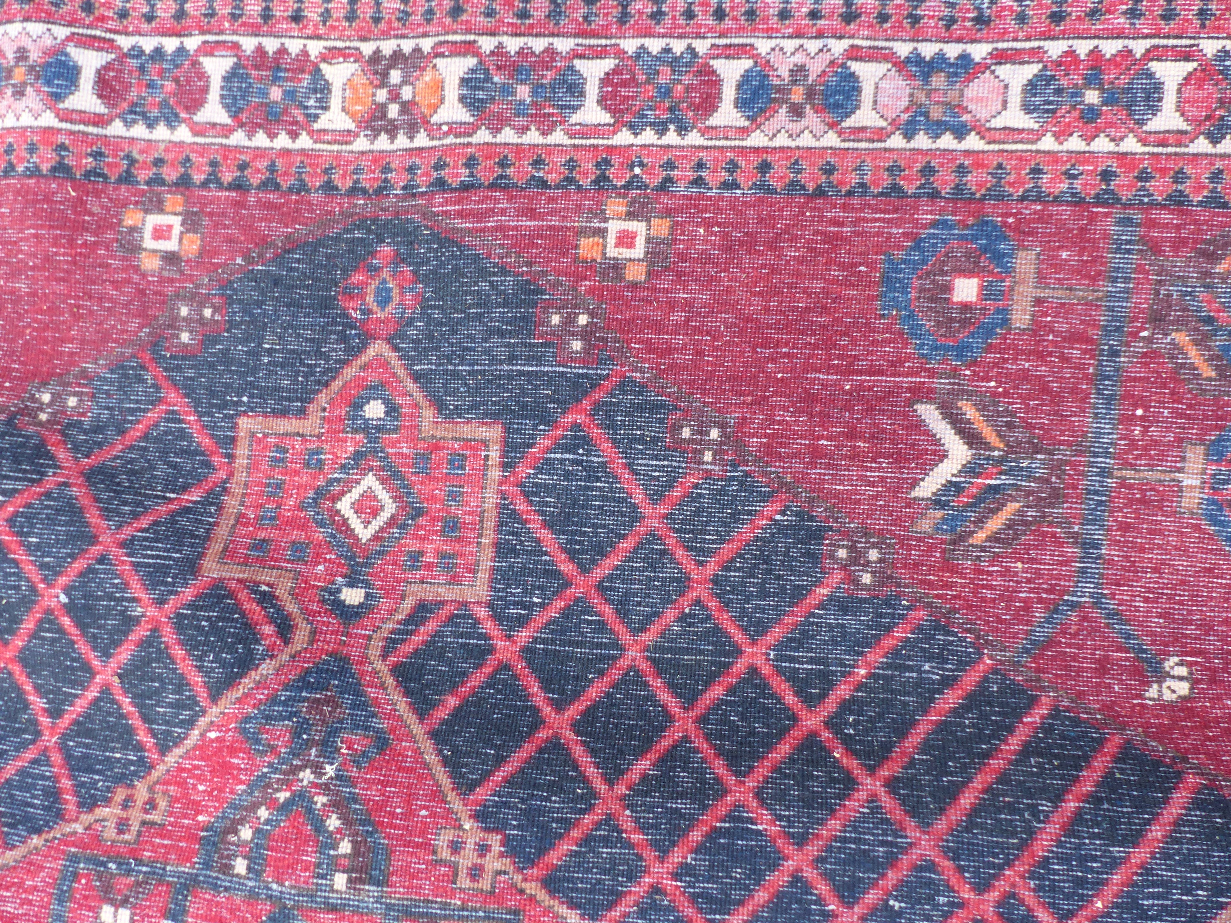 A Persian Shzad hand made red ground rug with stylised flowers to corners and Islamic script to - Image 3 of 3