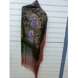 An Art Deco lamé fringed evening shawl woven with daisies on a black ground,