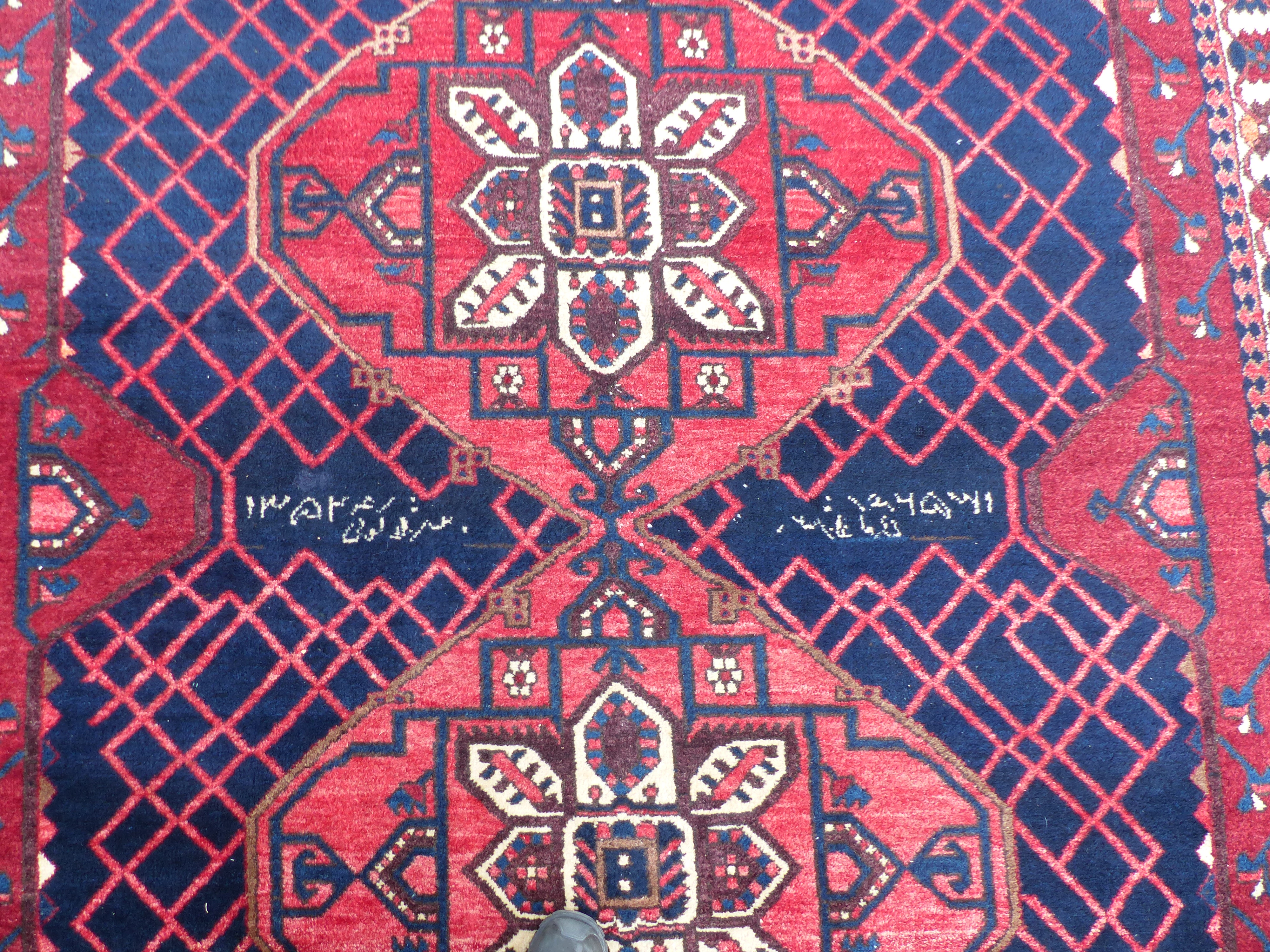 A Persian Shzad hand made red ground rug with stylised flowers to corners and Islamic script to - Image 2 of 3