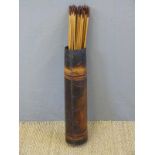 Thirty-six wooden barbed metal tipped wooden hunting arrows in leather quiver.