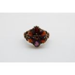 A 9ct gold ring set with garnets in a large flower cluster, 4.