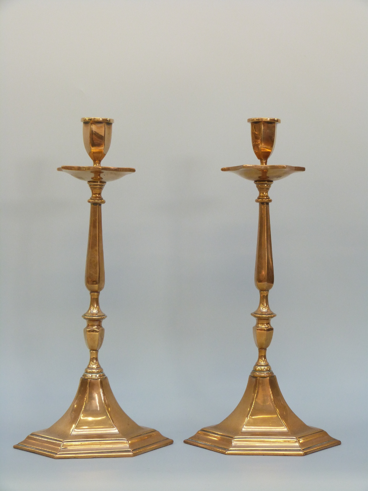 A pair of bronze or similar cast hexagonal candlesticks,