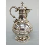A Victorian hallmarked silver ecclesiastical pedestal wine jug, with cork top and cross surmount,