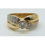 A 14ct gold ring set with a diamond with further diamonds to the shoulders,