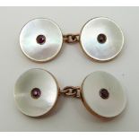 A pair of rose gold cufflinks set with pink paste to the centre and mother of pearl