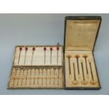 A cased set of six French silver gilt and ivory cocktail stirrers and cased set of twelve white